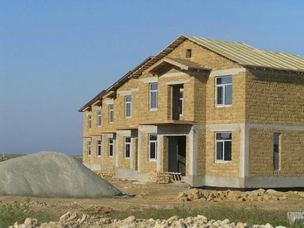 Na zdjęciu - dom z ramą i ścian betonowych i szczytami wapienia.